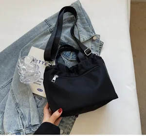 Detail of black waterproof nylon bucket bag with silver zipper and adjustable strap