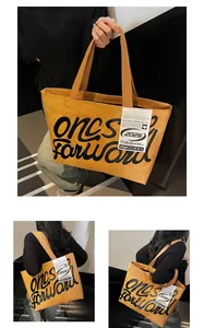 Detail of yellow waterproof tote bag with black typography on casual urban background
