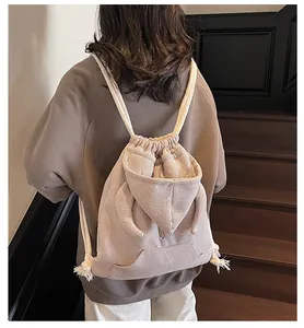 Detail of waffle fabric texture and cute rabbit ears on beige drawstring backpack