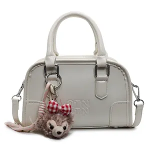Chic off-white embossed leather Boston handbag with detachable plush charm and shoulder strap