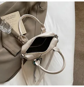 Top view of cream leather handbag interior with zipper pocket and metal hardware detail
