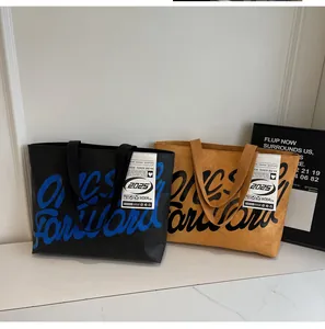 Close-up of black and tan waterproof tote bags featuring artistic Forward 2025 printing