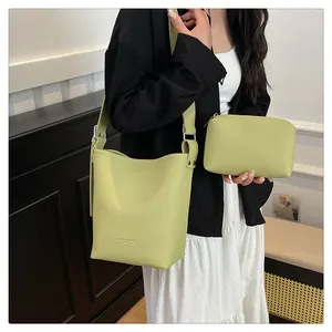 Detail of green pebble grain bucket bag and matching pouch set with shoulder strap