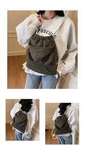 Detail of dark grey-green waffle texture backpack with white cotton drawstring straps