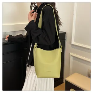 Detail of avocado green bucket bag with lychee texture and adjustable shoulder strap