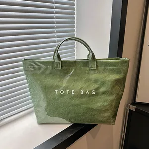 Dettaglio della borsa tote verde in Tyvek con strato impermeabile in PVC e testo bianco