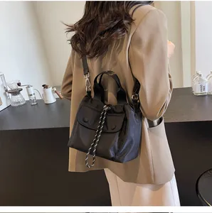 Detail of black nylon drawstring bucket bag with adjustable strap shown in a lifestyle setting