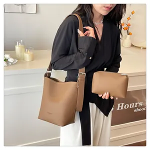 Detail of a brown lychee pattern leather tote bag with silver buckle and matching pouch