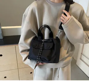 Detail of black nylon drawstring bucket bag with adjustable wide strap on model