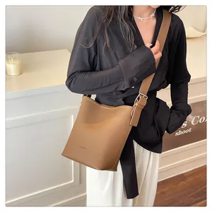 Close-up of brown litchi pattern leather bucket bag with adjustable wide shoulder strap