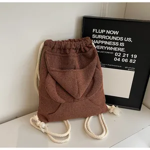 Detail of brown waffle-knit texture and soft drawstring straps on casual backpack
