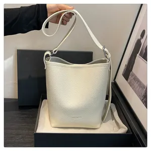 Close-up of cream lychee texture bucket bag with adjustable strap and silver metal buckle