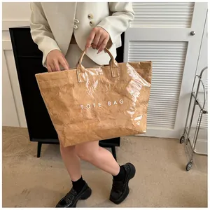 Dettaglio della borsa tote in Tyvek marrone impermeabile con texture e testo bianco