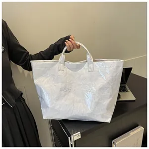 Dettaglio macro della borsa tote in Tyvek bianco con scritta TOTE BAG in rilievo e trama