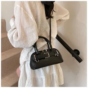 Detail of a black matte shell bag with silver metal buckles and double zipper closure