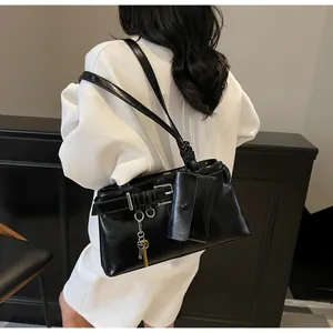 Detail of black faux leather tote with belt buckle accents and small hanging pouch