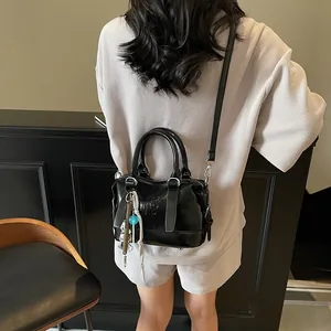 Chic black embossed crossbody bag with detachable charms and Rhino Pad lettering