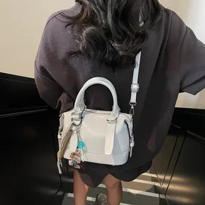 Chic light blue embossed Boston handbag with top handles and adjustable shoulder strap