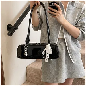 Vue détaillée du sac sous le bras en cuir verni noir avec cœurs et nœud en dentelle