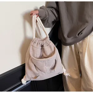 Detail of pink plaid drawstring backpack with hoodie pocket and cotton rope handles