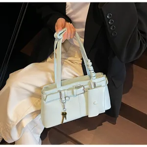 Chic light green shoulder bag featuring metal key charm and pleated strap details