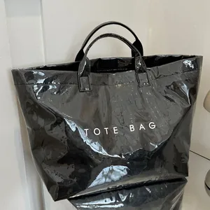 Borsa tote nera lucida in carta Tyvek con stampa TOTE BAG e ampia capacità per pendolari