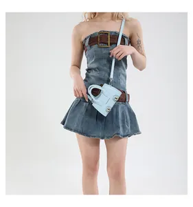 Detail of light blue mini motorcycle bag charm with metal studs and fashion text