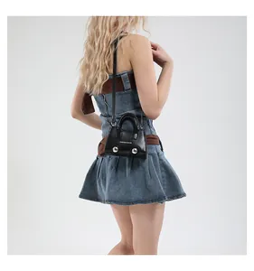 Detailed view of mini black leather shell bag with silver metal balls and shoulder strap