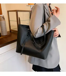 Detailed view of large black pebble grain leather tote bag with slim handles for work