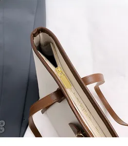 Detail of premium gold metal zipper and textured leather top of large tote bag