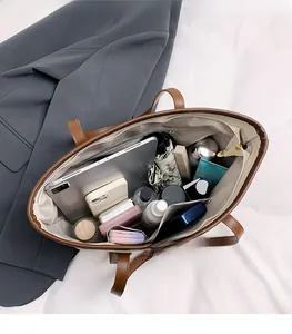 Macro view of a large brown tote bag showing organized interior compartments and ample space