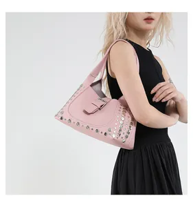 Dettaglio della borsa rosa in pelle litchi con rivetti argentati e fibbia su modella