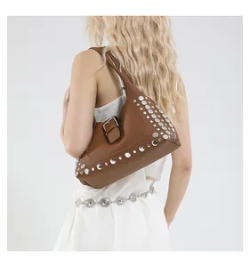 Dettaglio di borsa sottobraccio in pelle marrone con borchie argento e stile vintage