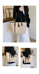 Detailed macro view of litchi textured leather tote bag with stylish brown contrast handles