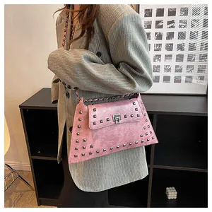 Vue détaillée du sac en similicuir rose avec clous carrés argentés et bandoulière