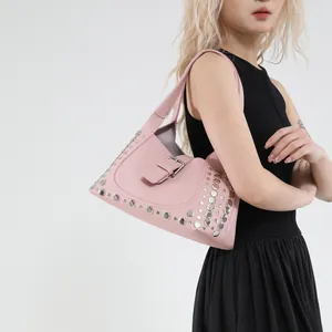 Borsa hobo in pelle rosa con borchie argento e fibbia indossata a spalla da donna