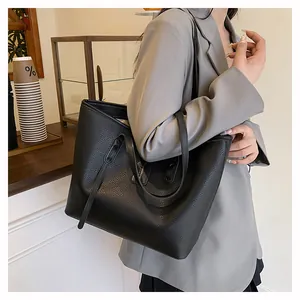 Black tote bag with lychee pattern shown in a cafe setting for daily commuting