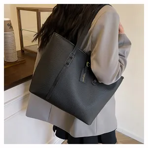 Close-up of black lychee grain leather tote bag with fashion tag on a female model
