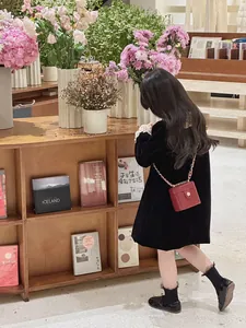 Gros plan d'un petit sac en cuir verni rouge avec chaîne dorée et fermoir floral