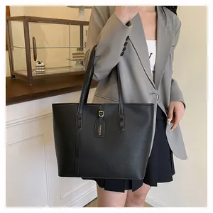 Close-up of black lychee grain leather tote bag with elegant fashion brand tag details