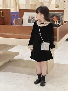 Détail d'une robe en velours pour fille avec volants et nœud dans un magasin de disques