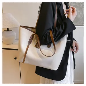 Detail of large tote bag in beige lychee leather with brown strap for daily commuting
