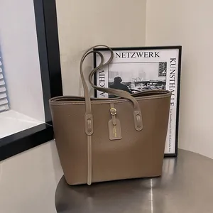 Minimalist large capacity tote bag in pebbled brown leather for daily commuting style