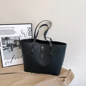 Minimalist large black faux leather tote bag with lychee texture and golden hardware