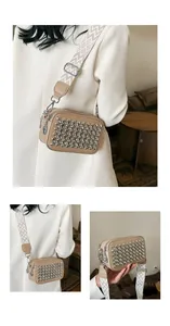 Detail of khaki camera bag featuring silver rivets and wide chevron patterned strap