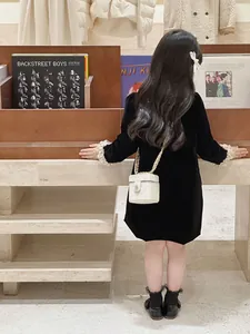 Mini sac boîte matelassé blanc porté avec une robe élégante en velours noir