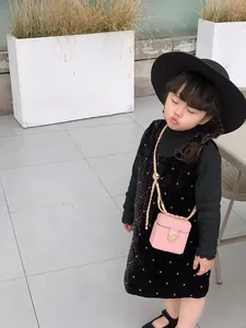 Vue détaillée du mini sac rose matelassé avec fermoir fleur dorée sur l'enfant