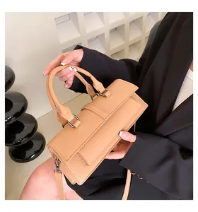 Detail der kamelfarbenen Ledertasche mit matter Textur und dunklen Metallakzenten
