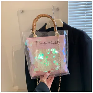 Detailed shot of transparent PVC tote bag with pink sequin insert and bamboo style handle
