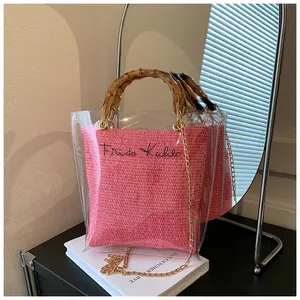 Detail of pink woven bag with Frida Kahlo script and transparent PVC shell and bamboo handle